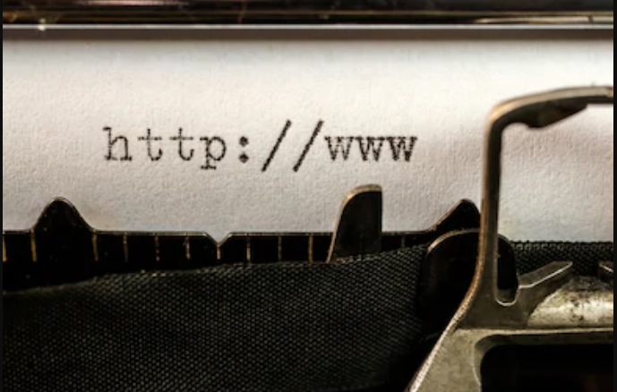 A typewriter writing a URL onto paper.